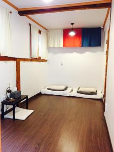 twee bedden in een kamer met een houten vloer bij Hanok Got in Seoul