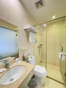 a bathroom with a sink and a toilet and a shower at GreenTree Inn Shenzhen Guanggang Port Futian South Road Express Hotel in Hong Kong +288 photos