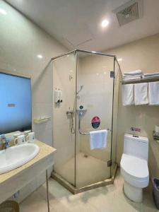 a bathroom with a shower and a toilet and a sink at GreenTree Inn Shenzhen Guanggang Port Futian South Road Express Hotel in Hong Kong