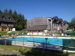 a large swimming pool in front of a building at Résidence Le Bois de la Reine in Super Besse