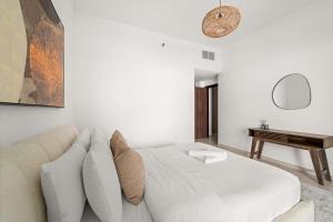 a white living room with a couch and a table at Silkhaus Sea View 1BDR Stay in Saadiyat Island in Abu Dhabi