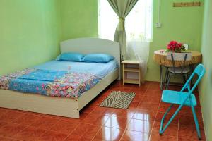 een slaapkamer met een bed, een tafel en een stoel bij Chez Ronald Guest House in Rodrigues Island
