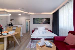 a living room with a bed and a kitchen at FeWo Buchenfreund - Meerblick, Sauna, Kamin in Sassnitz