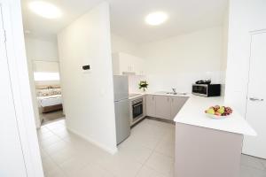 a white kitchen with a bowl of fruit on a counter at Oaks Middlemount Suites in Middlemount