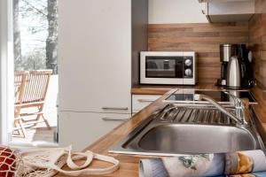 a kitchen with a sink and a microwave at Sassnitz - Kamin, Meerblick, Sauna, Fitness - FeWo Haubentaucher in Sassnitz