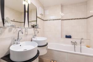 a white bathroom with a sink and a bath tub at Sassnitz - Kamin, Meerblick, Sauna, Fitness - FeWo Haubentaucher in Sassnitz