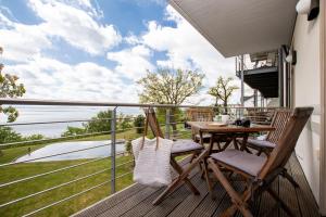 a deck with a table and chairs on a balcony at Sassnitz - Kamin, Meerblick, Sauna, Fitness - FeWo Haubentaucher in Sassnitz +10 photos