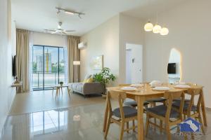 a dining room and living room with a table and chairs at Sunshine Residence Suites in Ayer Itam