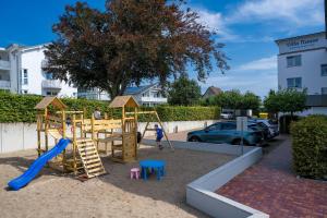 a playground with a slide and a swing set at FeWo Dwarslöper in Sassnitz