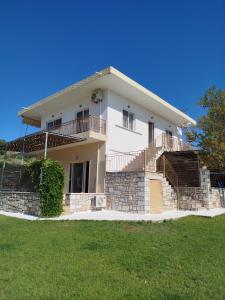 a large white house with a lawn in front of it at Nereids Apartments-Thetis in Petalidi