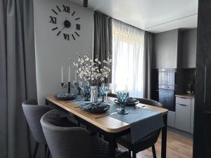 a dining room table with chairs and a clock on the wall at Narva Edukorter in Narva