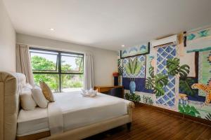 a bedroom with a white bed and a window at Amelia D Art Deco Suites in Seminyak +103 photos