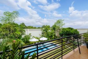 a balcony with a swimming pool and trees at Amelia D Art Deco Suites in Seminyak