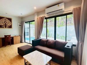 にあるMTM Pool Villaのソファとテーブルのあるリビングルーム +2枚の写真