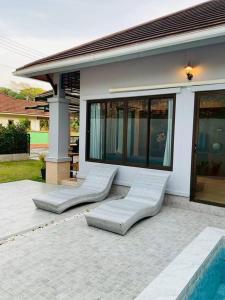 にあるMTM Pool Villaの家の前に座るラウンジチェア2脚