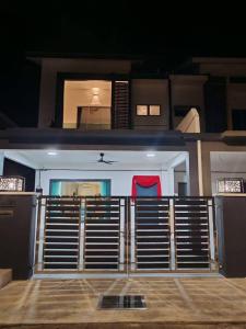 a house with a gate with a red seat at 52 Homestay Pangkor in Pangkor