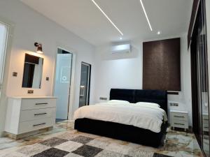 Un dormitorio con una cama, una cómoda y un espejo. en Private 5BR Villa with Sunset Rooftop, BBQ zone, Private Pool and Quiet Luxury near sea, en Klorakas 34 fotos más