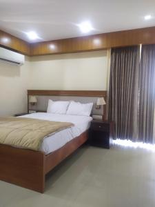 a bedroom with a large bed and a window at Premium ,modern 2 rooms apartment in Thiruvalla
