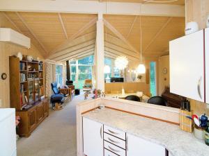 a kitchen with white cabinets and a living room at 5 star holiday home in Græsted in Udsholt Sand