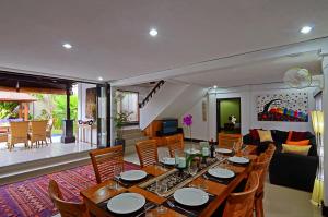 a dining room with a table and a living room at Villa Kibbi in Seminyak