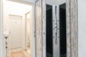 a bathroom with a shower with a glass door at Budget 1BR Studio near Danube & Millenium Tower in Vienna +28 photos