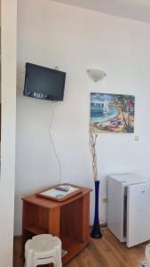 a room with a table and a tv on a wall at Penthaus Cacao Beach in Sunny Beach