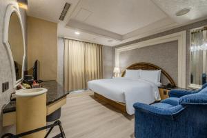 a hotel room with a bed and two chairs at Retro Kaohsiung in Kaohsiung +42 photos