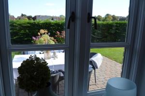 ein Fenster mit Blick auf einen Tisch und Blumen draußen in der Unterkunft Hardesweg 63 Nr 3 in Boldixum + 16 Fotos