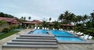 a swimming pool with stairs leading to a resort at Aloha Seaside Resort in Siquijor