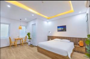 a bedroom with a bed and a table and chairs at apartment in Da Nang