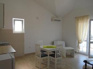 eine Küche und ein Esszimmer mit einem Tisch und Stühlen in der Unterkunft Apartments Kanli Kula in Herceg-Novi