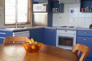 a kitchen with a table with a bowl of oranges on it at Beachsider upstairs in Whitianga