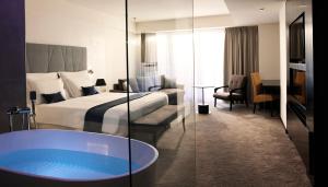 Hotel Slovenija - Terme & Wellness LifeClass في بوروتوروج: غرفة الفندق بسرير وحوض استحمام