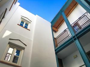 un edificio blanco con adornos y ventanas azules en El Baciyelmo, en Trujillo