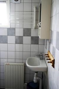 a small bathroom with a sink and a radiator at Gånarps backaväg 39 in Tåstarp