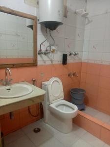 a bathroom with a toilet and a sink at Hotel Girish Inn in Pilerne