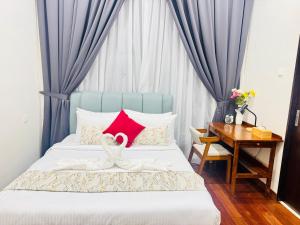 a bedroom with a bed with a red pillow and a desk at TM Persiaran Stonor BY PANORAMA in Kuala Lumpur