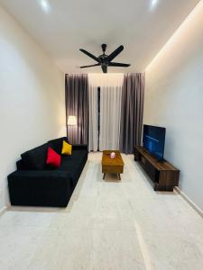a living room with a black couch and a ceiling fan at TM Persiaran Stonor BY PANORAMA in Kuala Lumpur