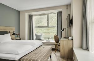 a hotel room with a bed and a window at Fru Haugans Hotel in Mosjøen