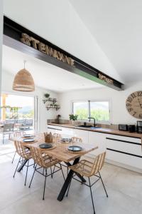 a dining room with a table and chairs in a kitchen at Splendid villa with swimming pool & sea view in Saint-Peïre-sur-Mer +15 photos