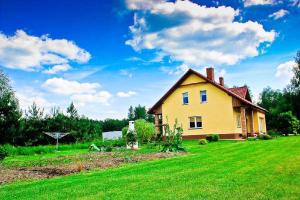 a yellow house in a field with a green yard at dom Bartków kielce in Zagnańsk