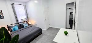 a bedroom with a bed and a table with a plant at Newly Renovated 2B 2BA apt! mins to PATH & NY! in Jersey City