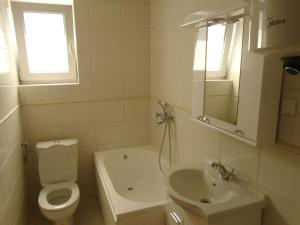 ein weißes Bad mit einem WC und einem Waschbecken in der Unterkunft Apartments Kanli Kula in Herceg-Novi