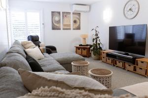 Una sala de estar con un sofá y un televisor de pantalla plana. en The View at Kingston Beach, en Kingston Beach