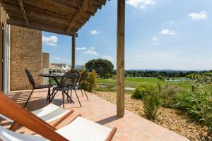 Madame Vacances Résidence Provence Country Club في Saumane-de-Vaucluse: فناء مع كراسي وطاولة مطلة