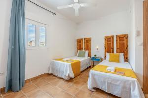 a bedroom with two beds and a window at Casa Mercedes In Granada's Vega in Valderrubio