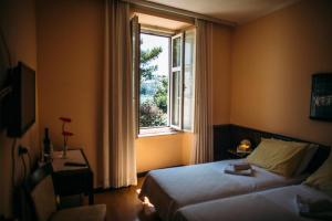a hotel room with a bed and a window at Rooms Villa Amfora Dubrovnik in Dubrovnik