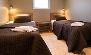 twee bedden in een kamer met handdoeken erop bij Tomelilla Golf Hotell in Tomelilla