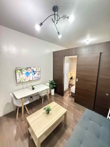 a living room with a table and a tv on the wall at Makati One Bed Room with Balcony Air Residence SMDC in Sampong