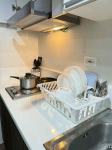 a kitchen with dishes in a drying rack on a sink at Makati One Bed Room with Balcony Air Residence SMDC in Sampong